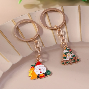 Detail of Christmas keychains with Santa Claus and tree charms on a ceramic tray