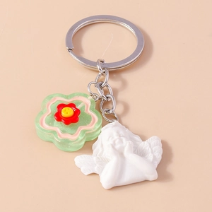 Detail of creative keychain with green resin flower and white angel relief charm