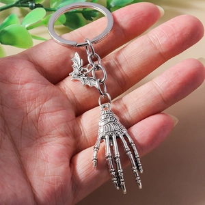 Gothic silver metal keychain with detailed bat wings and human skeleton hand charms