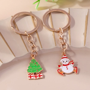 Golden Christmas snowman and green tree keychain set with colorful enamel finish