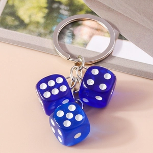 Close-up of three blue translucent acrylic dice charms on a silver keychain chain