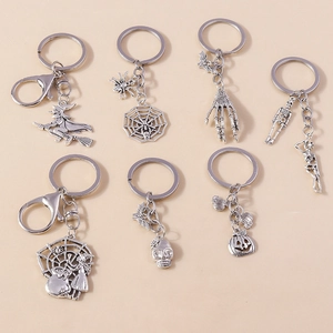 Close-up of vintage silver Halloween charms featuring skeletons, witches, and pumpkins