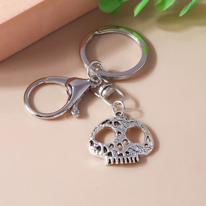 Close-up of retro silver skull keychain with detailed hollow texture and lobster clasp