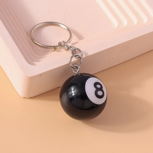 Porte-clés créatif boule de billard n°8 noire avec anneau en métal sur plateau rose