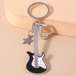 Close-up of a cartoon guitar keychain with enamel finish, star charm and heart clasp