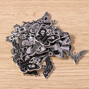 Detailed view of Gothic alloy charms with black enamel bats, moths and skull designs