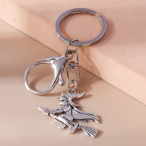 Macro shot of a vintage silver witch on broomstick charm with lobster clasp keyring