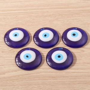 Vue macro de cinq pendentifs œil maléfique en résine bleu foncé avec trous percés