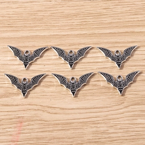 Detailed macro view of six black bat pendants with silver edges for DIY jewelry making
