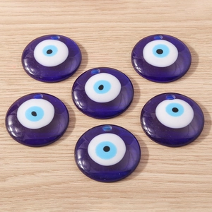 Macro de six pendentifs œil de démon en résine bleue sur une surface en bois rustique