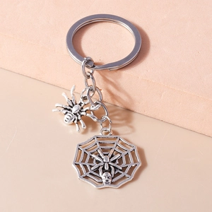 Detail of gothic silver spider and skull web keychain with vintage metal finish