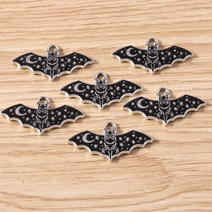 Detail of black enamel bat pendants with moon and star patterns for DIY jewelry making