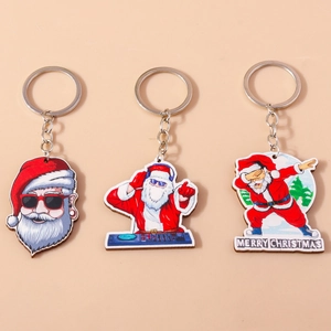 Detailed view of three acrylic Santa Claus keychains including a DJ and skiing theme