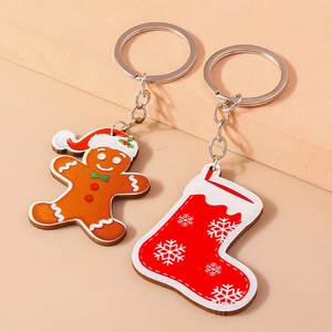Close-up of Christmas gingerbread man and sock charms with silver metal keychains