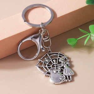 Detail of silver vintage Halloween keychain with embossed witch and spider web charm