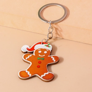 Christmas gingerbread man keychain with red hat and green bow on khaki display stand