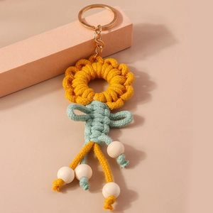 Detailed close-up of handmade macrame sunflower keychain with cotton weaving and wooden beads