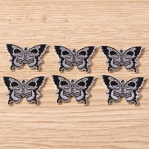 Detail view of 6 gothic metal butterfly skull charms with black enamel finish and DIY loop