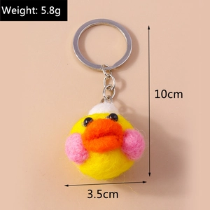 Detail of handmade yellow felt duck keychain with silver metal ring and soft wool texture