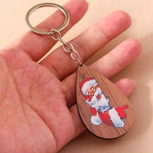Vista dettagliata del portachiavi in legno a goccia con stampa di Babbo Natale in mano