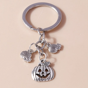Close-up of silver metal Halloween keychain featuring three Jack-o'-lantern pumpkin charms