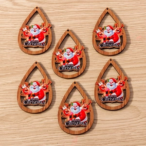 Detalle de colgantes de gota en madera con motivos navideños para joyería artesanal