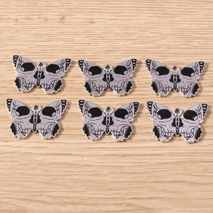 Detail of Gothic butterfly skull metal charms with silver plating and black enamel inlay