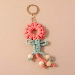 Handmade knitted sunflower keychain in pink and green with wooden beads and gold ring