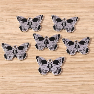 Macro detail of gothic skull butterfly charms with black enamel finish for DIY jewelry
