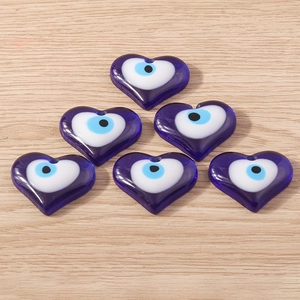 Vue macro de six breloques oeil maléfique bleues en forme de coeur pour bijoux DIY