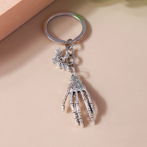 Close-up of vintage gothic keychain with silver bat and skeleton hand charms on a ring