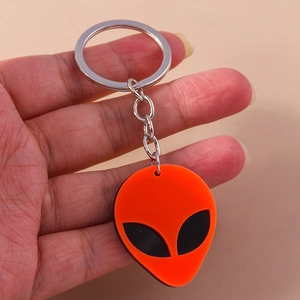 Macro shot of an orange punk alien silicone keychain with metallic silver ring and chain