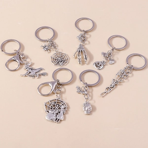 Detailed set of seven silver Halloween keychains featuring pumpkins, witches, and skulls