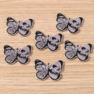 Detail of DIY skull butterfly charms with black and grey enamel finish and silver outlines