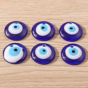Détail de six perles en verre œil grec bleu sur fond bois clair pour création de bijoux