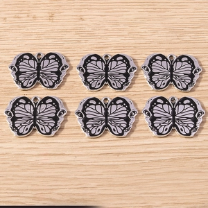 Detail of DIY bat butterfly pendants in black and lilac enamel with top hanging rings