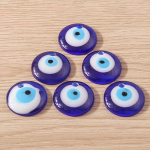 Vue détaillée de six pendentifs mauvais œil en verre bleu sur une surface en bois
