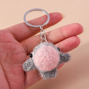 Detailed view of handmade grey wool felt chick keychain with silver metal ring