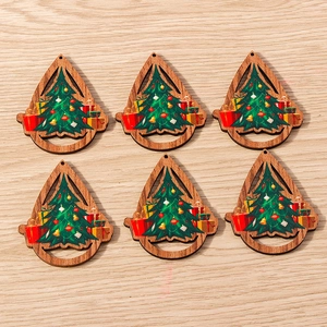 Detalle de adornos navideños de madera en forma de gota con estampados de árboles y regalos