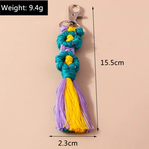 Detailed view of handmade woven flower keychain with blue tassels and silver clasp