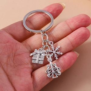 Detailed view of silver Christmas keychain with gift box, snowflake, and tree charms