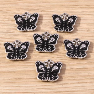 Detail of silver butterfly charms with black skull wings for dark gothic DIY jewelry making