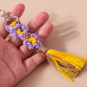 Handmade woven flower keychain with purple and yellow cotton tassels and silver lobster clasp