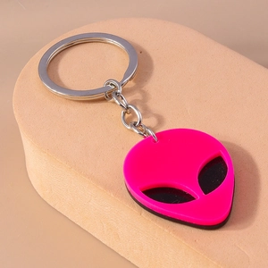 Macro detail of a punk style alien keychain made of layered neon pink and black acrylic