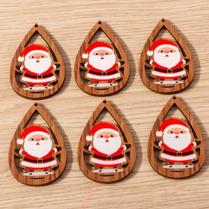 Detalle macro de seis adornos navideños de madera en forma de gota con Papá Noel pintado a mano