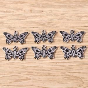 Detailed view of Gothic butterfly coffin charms with skull wings for DIY jewelry making