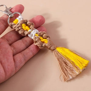 Detail of bohemian handmade woven tassel keychain with yellow cotton cord and lobster clasp