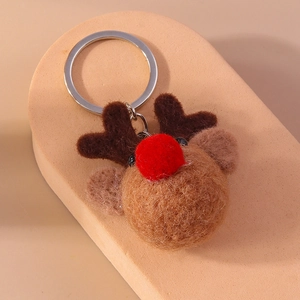 Detailed close-up of handmade reindeer plush keychain with wool felt texture and silver ring