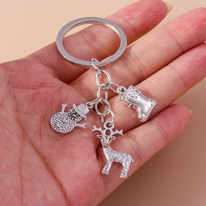 Close-up of silver Christmas keychain featuring snowman, elk, and stocking metal pendants
