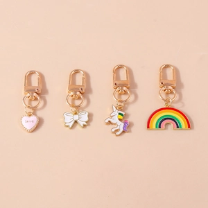 Detail of four colorful enamel keychains with unicorn, rainbow, heart, and bow pendants
